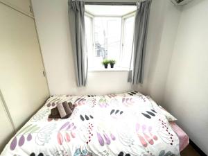 a bed in a small room with a window at Tokyo Stay Dolce in Tokyo