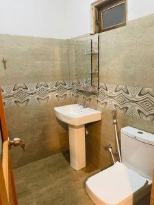 een badkamer met een toilet en een wastafel bij Lake Island Home Stay in Dambulla