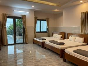 Hoàng Linh Hotel في بون ما توت: غرفة نوم بسريرين ونافذة كبيرة