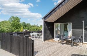 une terrasse en bois avec une table et des chaises sur une maison dans l'établissement Beautiful Home In Hjby With Kitchen, à Højby