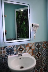 a bathroom with a white sink and a mirror at Amango Dorm in Ho Chi Minh City