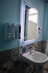 ein Bad mit einem Waschbecken und einem Spiegel in der Unterkunft Amango Dorm in Ho-Chi-Minh-Stadt