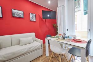 a living room with a red wall and a white couch and a table at [San Donato] Jewel Apartment in Florence