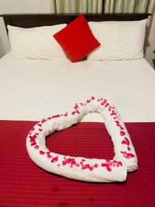Una cama blanca con un corazón hecho de rosas en Lake Island Home Stay, en Dambulla