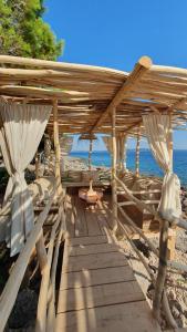 a wooden shelter on a beach with the ocean at Villa Hvar in Ivan Dolac