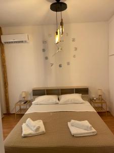 ein Schlafzimmer mit einem Bett mit zwei Handtüchern darauf in der Unterkunft MY HOME PERISTERI in Athen