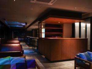 a bar in a restaurant with a row of chairs at REF Okinawa Arena by VESSEL HOTELS in Okinawa City