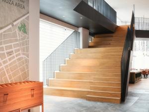 una escalera en un edificio con escalones de madera en REF Okinawa Arena by VESSEL HOTEL en Okinawa City
