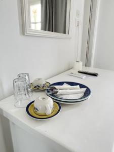 a white table with plates and dishes on it at Hotel Anezina in Drios