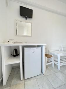 a white desk with a tv on top of it at Hotel Anezina in Drios