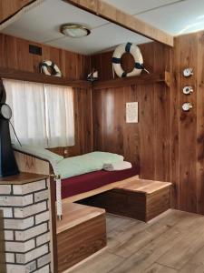 圣于尔萨讷Hostel Le Chandelier的一间卧室配有双层床和木墙