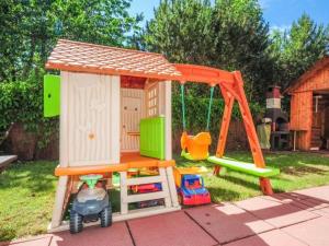 uma casa de brincar com um baloiço e um parque infantil em Bryza em Trzęsacz