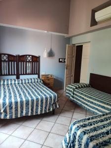 a bedroom with two beds with blue and white sheets at Agriturismo Le Macine in Silvi Marina