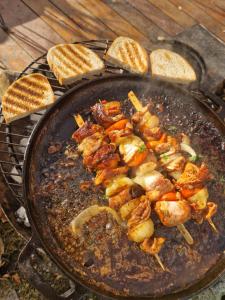 a pan with meat and bread on a grill at Glamping Stola- Šepot kvetov in Štôla