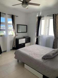 a bedroom with a bed and a ceiling fan at La Marquise in Flic-en-Flac