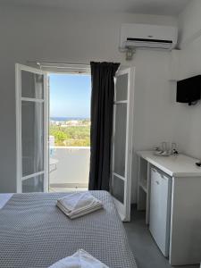 een slaapkamer met een bed en een raam met uitzicht bij Hotel Anezina in Drios