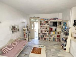 a living room with a couch and book shelves at Hotel Anezina in Drios