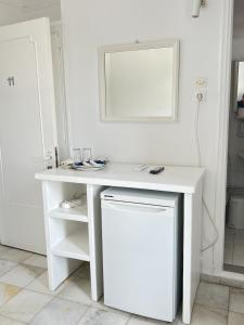 a white desk in a white room with a mirror at Hotel Anezina in Drios