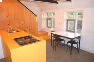 a kitchen with a sink and a table with chairs at Lindenhof Ferienhaus in Westereck