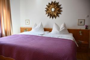1 dormitorio con cama morada y espejo en la pared en Villa Marwa - eine Ruheoase im Grünen, en Innsbruck