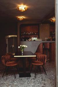 una sala da pranzo con tavolo, sedie e bar di Sia Boutique Aparthotel a Sibiu