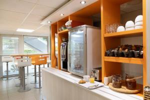 a kitchen with a counter top with a stove top oven at Premiere Classe La Ville Du Bois in La Ville-du-Bois