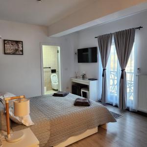 biała sypialnia z łóżkiem i łazienką w obiekcie My room accommodation w mieście Curtea de Argeş