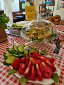 a plate of watermelon and cucumbers on a table at Hotel Vittoria in Riva del Garda