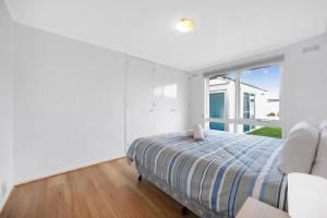 a bedroom with a bed and a large window at Logans Beach Apartments - Greenviews in Warrnambool