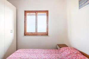 a small bedroom with a bed and a window at Sant'Alessio Village in SantʼAlessio Siculo
