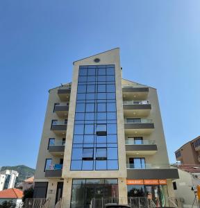un edificio alto con muchas ventanas en Dora Family Apartments Budva, en Budva