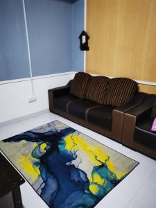 a living room with a couch and a colorful rug at Homestay Pokdin in Kuantan