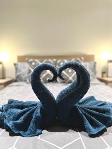 two towels in the shape of two hearts on a bed at Luxury 1 Bedroom Apartment in Adelaide CBD - 1 minute walk to Rundle mall - Free Wifi & Netflix in Adelaide