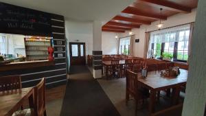 een restaurant met houten tafels en stoelen en een bar bij Ski park Gruň in Staré Hamry