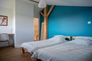 2 camas en una habitación con una pared azul en Villa Surf and Golf, en Messanges