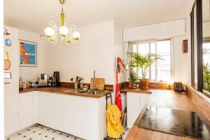 uma cozinha com armários brancos e um guarda-chuva amarelo em Bright apartment with double terrace em Paris