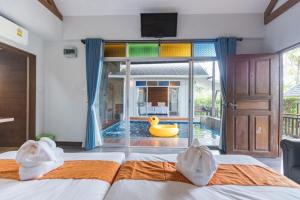 a bedroom with a pool with a rubber duck in the window at IP Plus Pool Villa Pattaya in Jomtien Beach