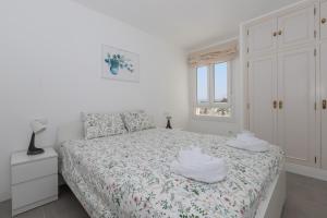biała sypialnia z łóżkiem i ręcznikami w obiekcie Apartamento en Sotomar La Carihuela w mieście Torremolinos +14 zdjęć