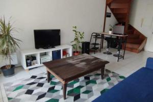 a living room with a coffee table and a television at T2 duplex + piscine avec parking in Montpellier