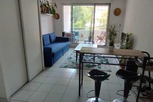 a living room with a blue couch and a table at T2 duplex + piscine avec parking in Montpellier