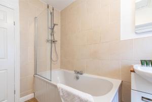 Un baño con ducha, bañera y lavabo. en Gertrude House - Spacious 3BR Bungalow in Nottingham, en Nottingham