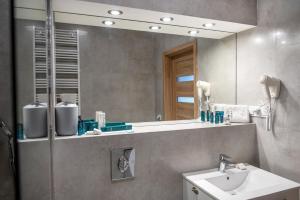 a bathroom with a sink and a mirror at Nowe Apartamenty z antresolą z 2 sypialniami - REWAL in Rewal