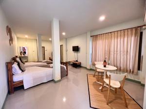 une chambre d'hôtel avec un lit, une table et des chaises dans l'établissement บ้านไทยไออุ่น, à Phra Nakhon Si Ayutthaya