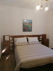 a bedroom with a bed and a painting on the wall at Sweet Home Casa Vacanze il b&b in Songavazzo