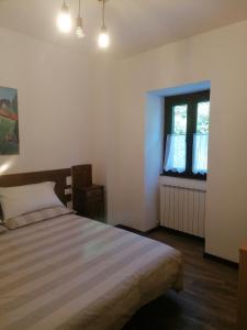Schlafzimmer mit einem Bett und einem Fenster in der Unterkunft Sweet Home Casa Vacanze il b&b in Songavazzo