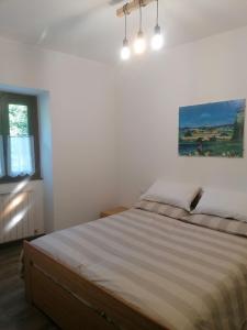 Schlafzimmer mit einem Bett mit Wandgemälde in der Unterkunft Sweet Home Casa Vacanze il b&b in Songavazzo