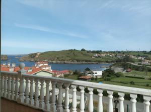 einen Blick von einem Balkon aus auf eine Stadt und einen Wasserkörper in der Unterkunft La Cariñosa in Naveces