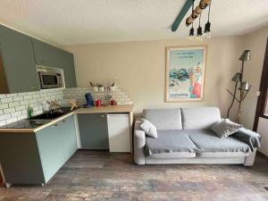 sala de estar con sofá y cocina en Studio refait à neuf avec balcon - Famille - Parking couvert en Chamrousse