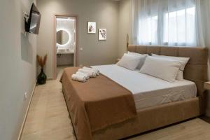 una camera da letto con un grande letto con asciugamani di Hypnos Hili a Alexandroupoli
