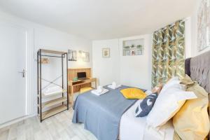 1 dormitorio con cama azul y espejo en Château de Versailles à 7 minutes plus parking gratuit à 4 minutes, en Le Chesnay